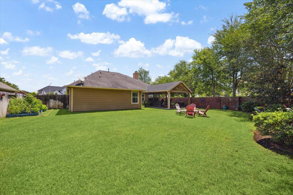 Enjoy endless possibilities for play, gardening, or relaxation in the oversized backyard framed by mature trees and privacy fencing.