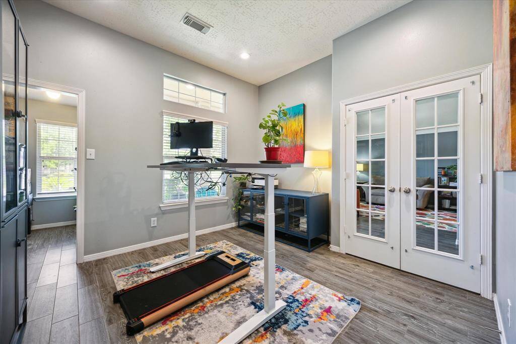 is private study with glass French doors and wood-look tile flooring is ideal for remote work or quiet focus. With its generous size and privacy, it can also serve as a fourth bedroom if needed.