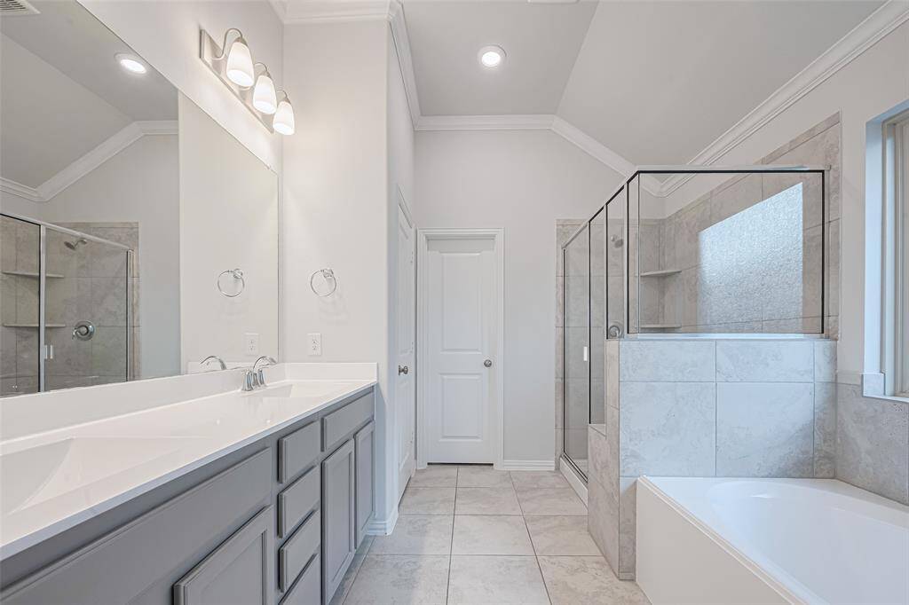 Primary ensuite with double vanity and glass enclosed shower