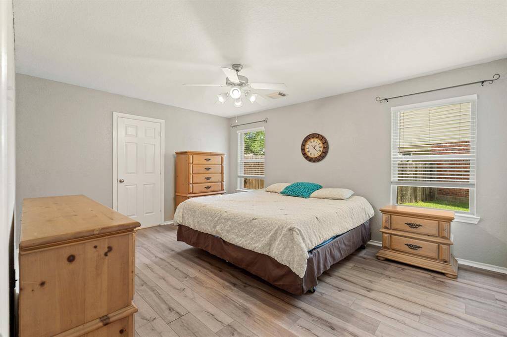 Downstairs primary bedroom features a comfortable layout with ample natural light from two windows.
