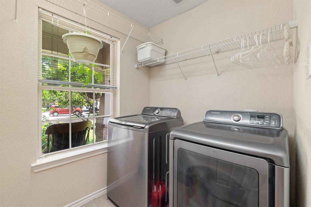 Laundry room features a window that brings in natural light, and a wire shelf above for storage.