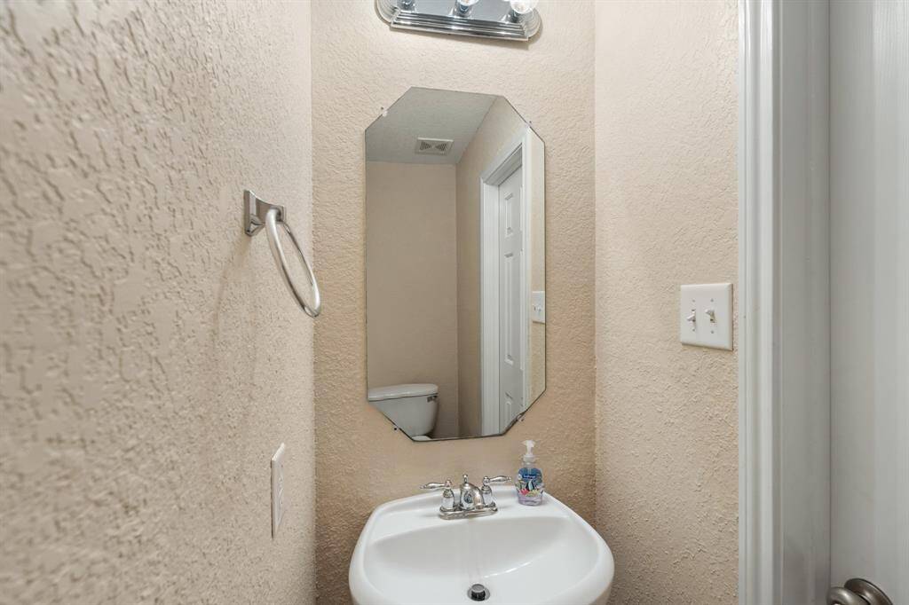 Half bath with pedestal sink downstairs for convenience.