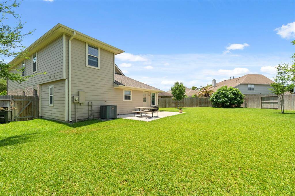 The house features a two-story design with a patio area, ideal for relaxation and entertaining. The property is fenced for privacy and security.