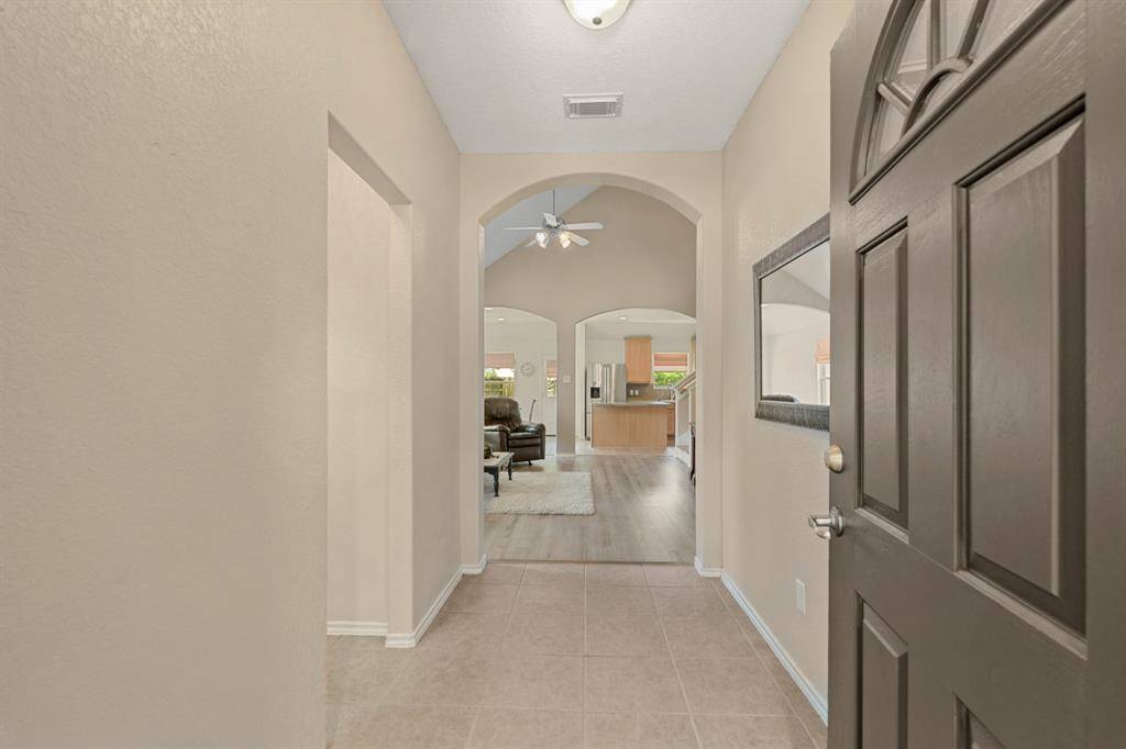 Bright, inviting entryway with tile flooring leading into an open living area.