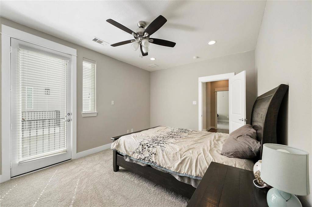 Staged. Another view of the primary bedroom with a private balcony.