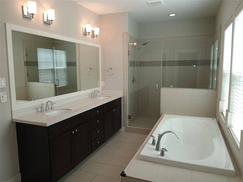 Spacious 8 foot by 16 foot primary bath with double sinks, plenty of cabinet space, large soaking tub to relax in and a huge glass enclosed shower.