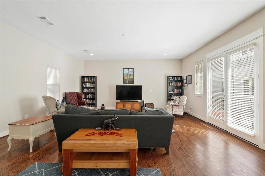Staged.  Another view of the living room with many windows for natural light.