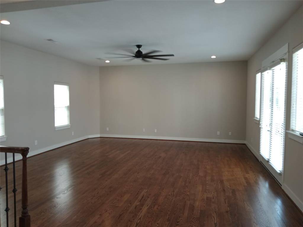 Spacious living room with hardwood floors and many windows to let the natural light in.