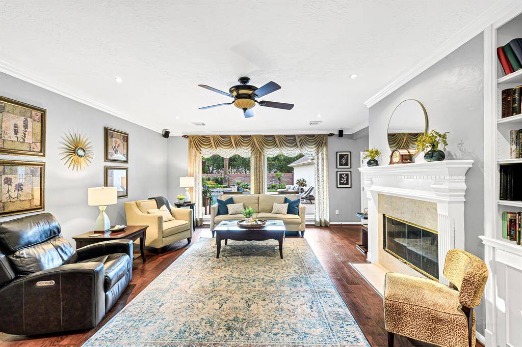 LOVELY FAMILY ROOM WITH FLOOR TO CEILING PICTURE WINDOWS WITH REMOTE CONTROLLED SHADES AND EXTRA LARGE FIREPLACE