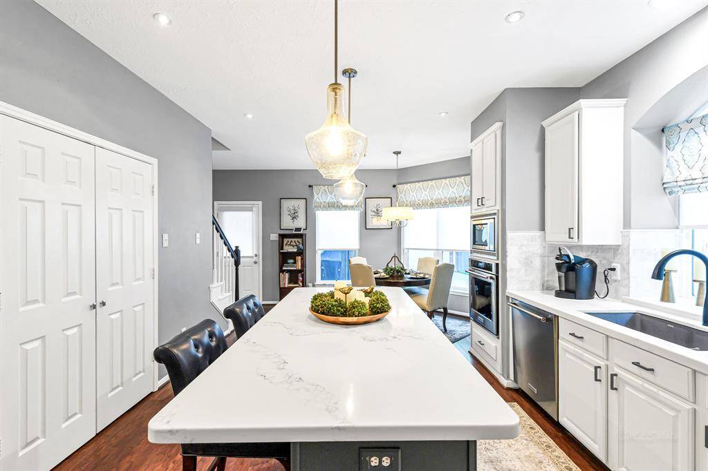 LARGE DOUBLE DOOR PANTRY WITH LOTS OF STORAGE SPACE AND OVERSIZED KITCHEN QUARTZ ISLAND