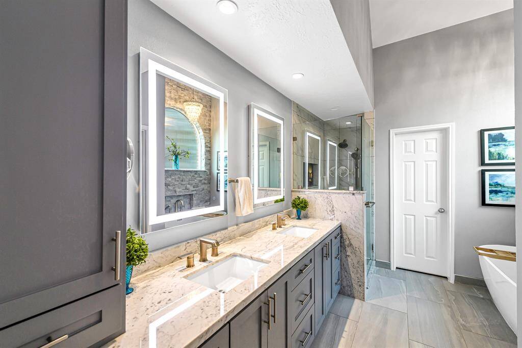 ELEGANT ENSUITE BATH INCLUDES DOUBLE SINKS ON GRANITE COUNTERTOP, CUSTOM CABINETRY, HIGH END VANITY MIRRORS