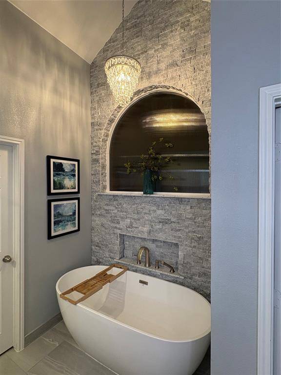 STACK STONE WALL FEATURE ABOVE OVERSIZED SOAKER TUB IS DEFINITELY THE HIGHLIGHT OF THIS ENSUITE BATHROOM!