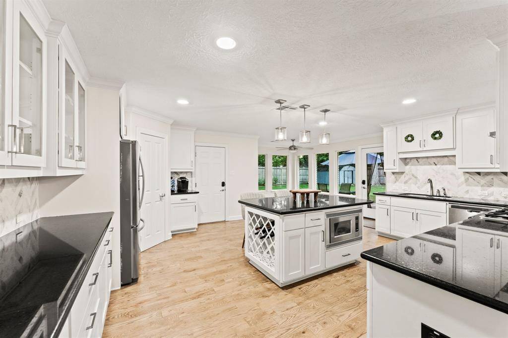 Kitchen island for two with bar lighting.  View of garage entrance and back yard separate access.