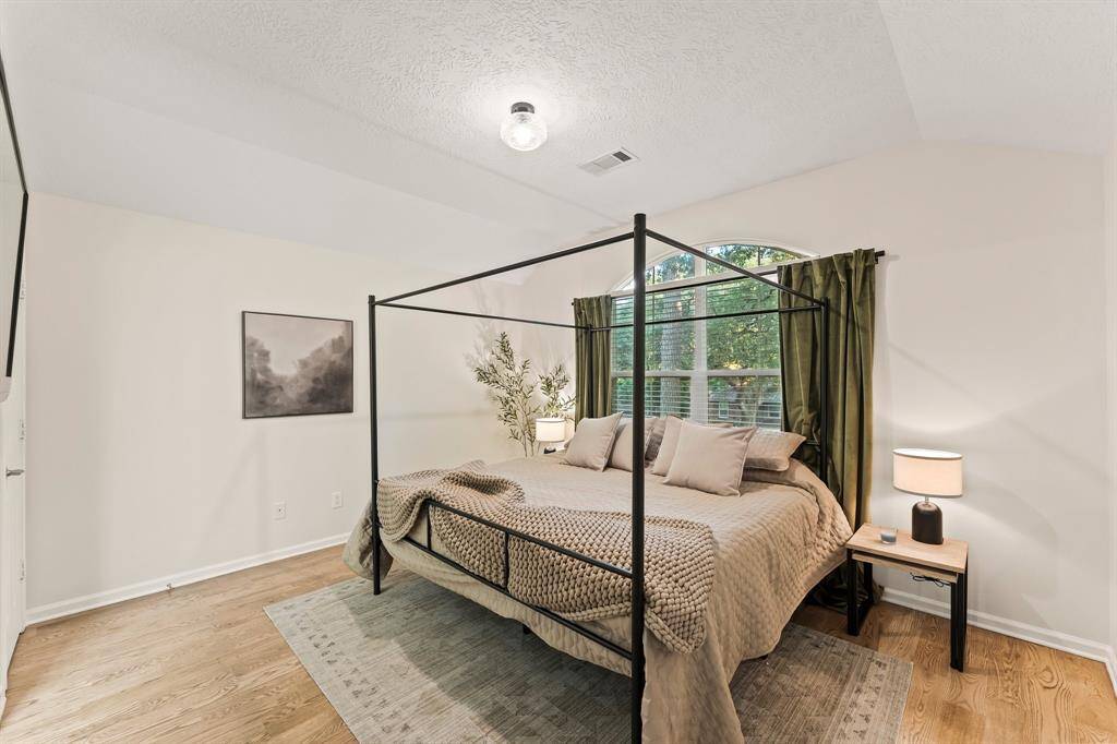 Bedroom 3 with king sized bed and still plenty of room! Vaulted ceiling with picturesque view of front yard oaks.  Walk-in closet just out of view.
