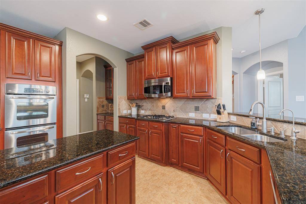 Kitchen also features double ovens and an undermount sink.