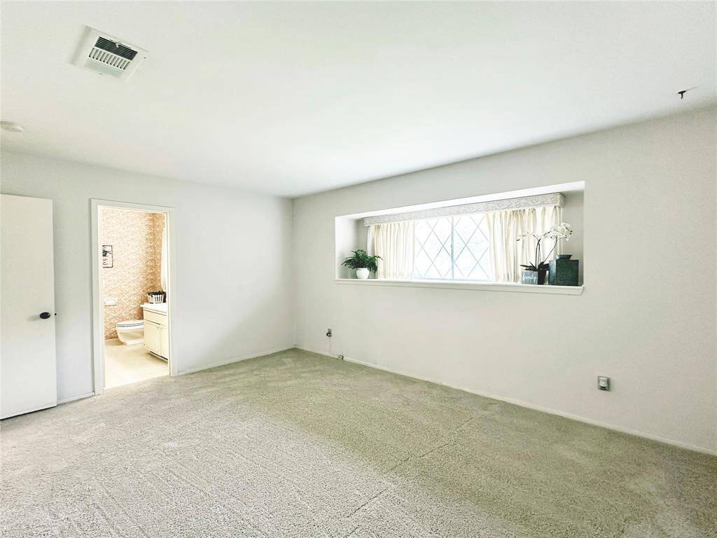 Primary Bedroom has fresh carpet.  A large window with display shelf offers lots of natural light.  A closet encompasses the entire wall with 2 doors for entry and easy access.
