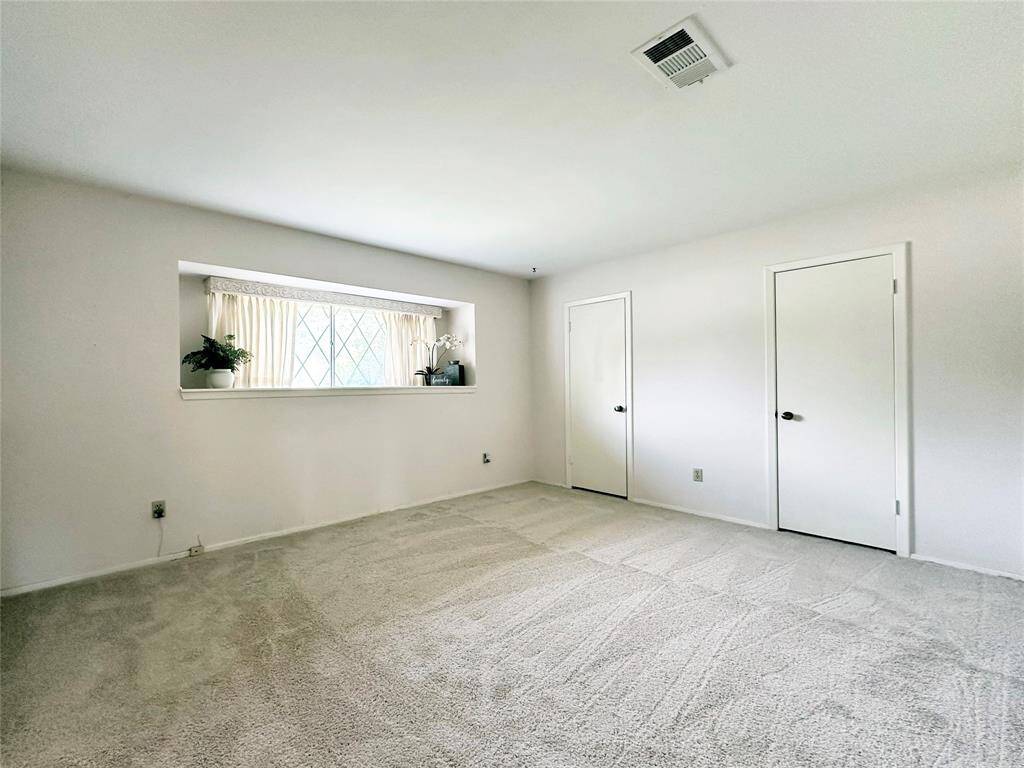 Primary Bedroom has fresh carpet.  A large window with display shelf offers lots of natural light.  A closet encompasses the entire wall with 2 doors for entry and easy access.