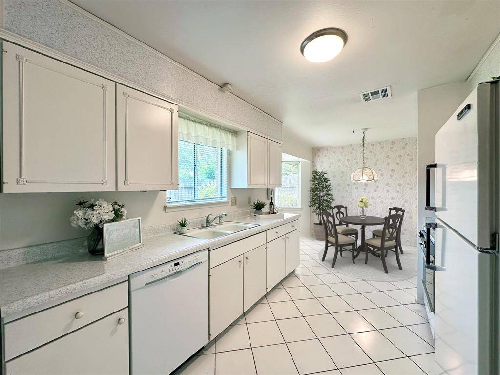 Spacious Kitchen with tiled flooring, and appliances included. Features a cozy breakfast nook with large windows and a decorative light fixture, offering a pleasant view and ample natural light. Image Virtually Staged.