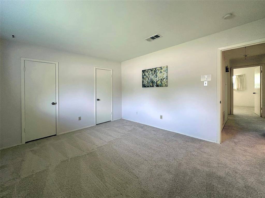Primary Bedroom has fresh carpet.  A large window with display shelf offers lots of natural light.  A closet encompasses the entire wall with 2 doors for entry and easy access.