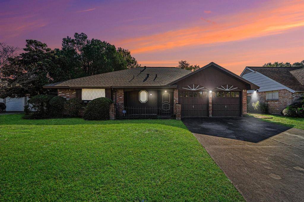 9615 Richmond is a Charming single-story brick home with a two-car garage, set against a beautiful sunset backdrop. The large front lawn and trees provide great curb appeal.