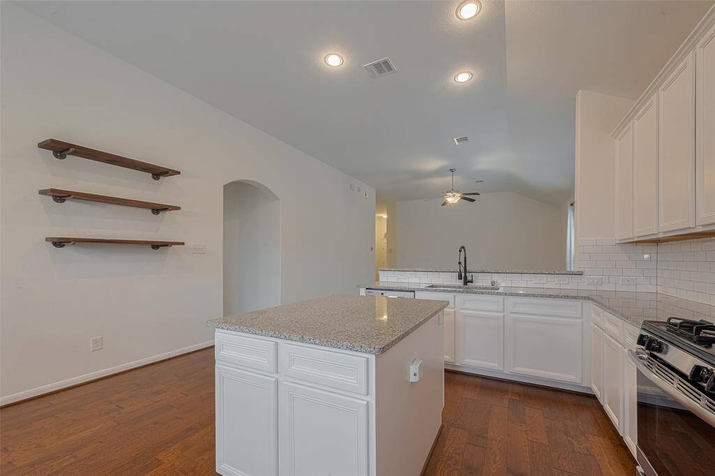 A curved archway adds architectural charm and leads gracefully into the primary suite, creating a sense of separation and flow while maintaining the open feel of the home.