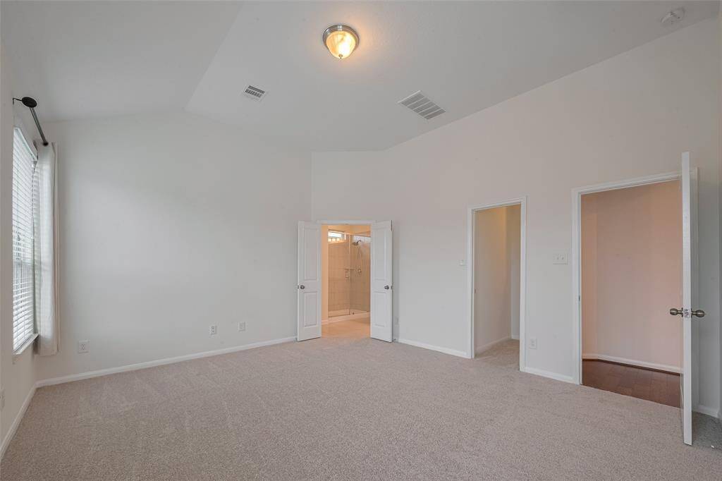 The spacious primary bedroom measures 15'3" x 13'9" and the suite includes an en-suite bathroom and two walk-in closets, offering both luxury and functionality.