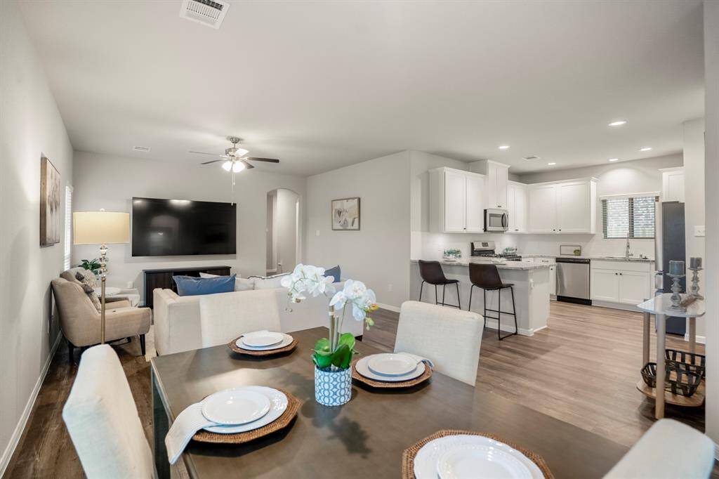 Here’s the full picture: from the breakfast table, your view extends into the living room, kitchen, and back toward the front hallway—showing off the home’s open concept in action. Whether you're hosting a group or just enjoying a quiet meal, the layout keeps everyone connected without feeling crowded.