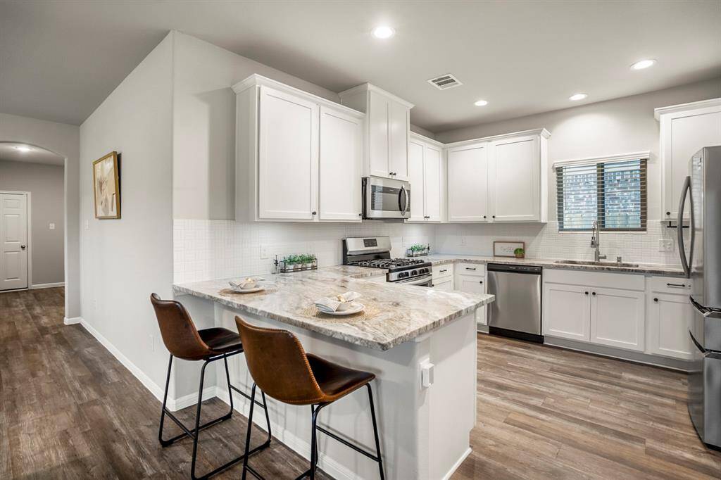 This kitchen brings the storage and workspace you’ve been searching for. With an abundance of upper and lower cabinetry, there’s a dedicated spot for everything—no creative stacking required. The wraparound counters offer plenty of prep space, and the oversized peninsula adds even more room to spread out (plus bar seating!). Stainless steel appliances, modern finishes, and cabinet hardware upgrades pull it all together.