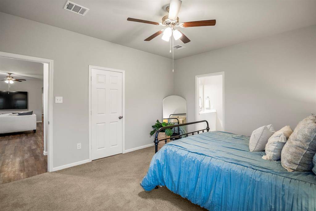 From this angle, you get a full sense of the primary suite’s layout. The doorway on the right leads into the private en suite bath, while the center door opens to a massive walk-in closet with plenty of room for storage, organization, and then some. And just beyond the open door on the left? The main living area, easily accessible but nicely separated for privacy.