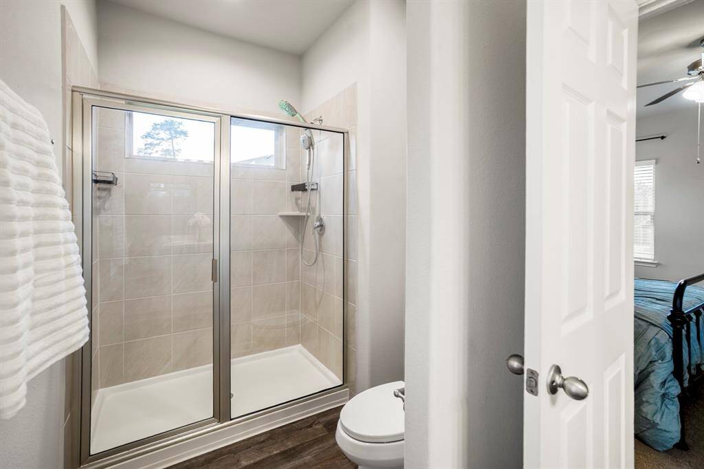 The walk-in shower in the primary suite features dual Kohler shower heads and built-in shelving for daily convenience. A transom window adds natural light while maintaining privacy, and the sleek tile surround keeps things feeling clean and modern—because even your morning routine deserves a little luxury.