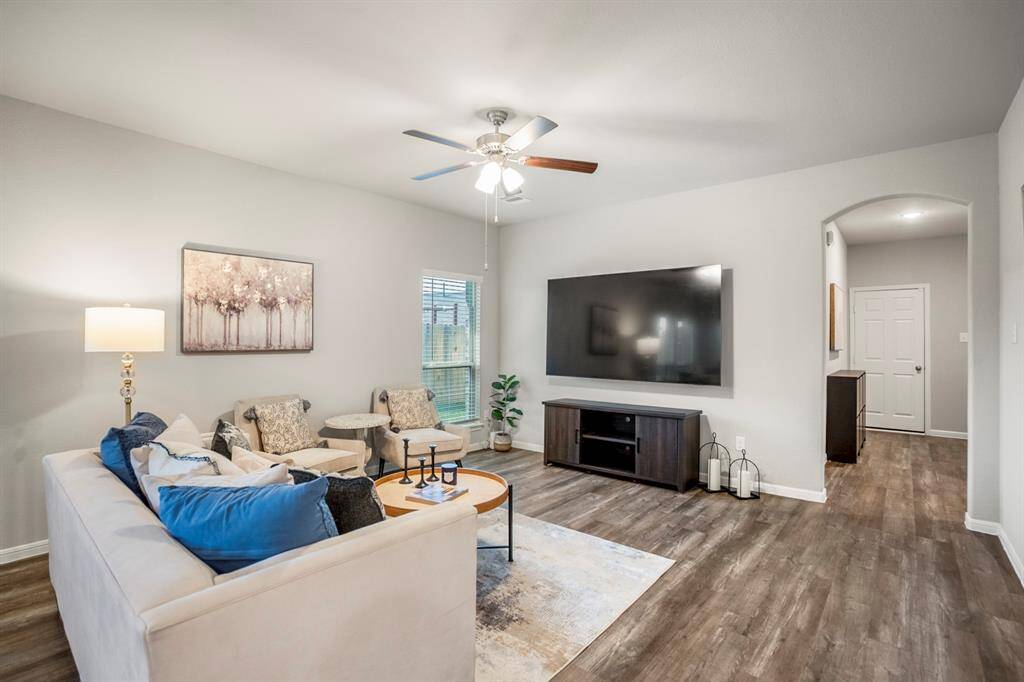 Looking back toward the front of the home, this hallway leads to both secondary bedrooms, the guest bath, and the door to the garage just beyond the arched opening. The layout keeps everything easily accessible while still giving each space a sense of separation and privacy.