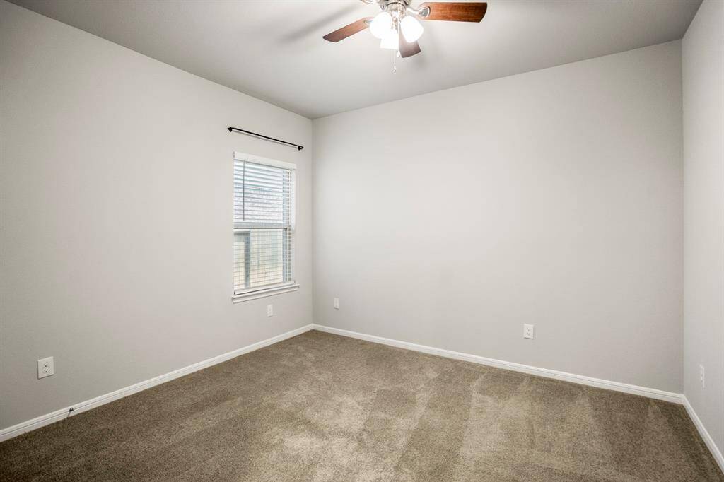 The third bedroom offers a clean slate with soft carpet, neutral paint, and another upgraded ceiling fan overhead. Tucked away in its own hallway near the guest bath, it’s a private, versatile space that could easily serve as a guest room, hobby zone, or anything in between.