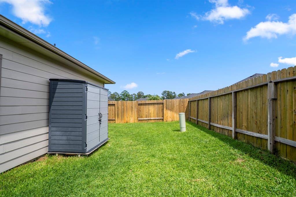 Tucked just behind the primary suite, this private corner of the backyard is perfect for stashing garden tools, storing holiday décor, or giving furry friends a space of their own. Bonus: the storage shed stays!