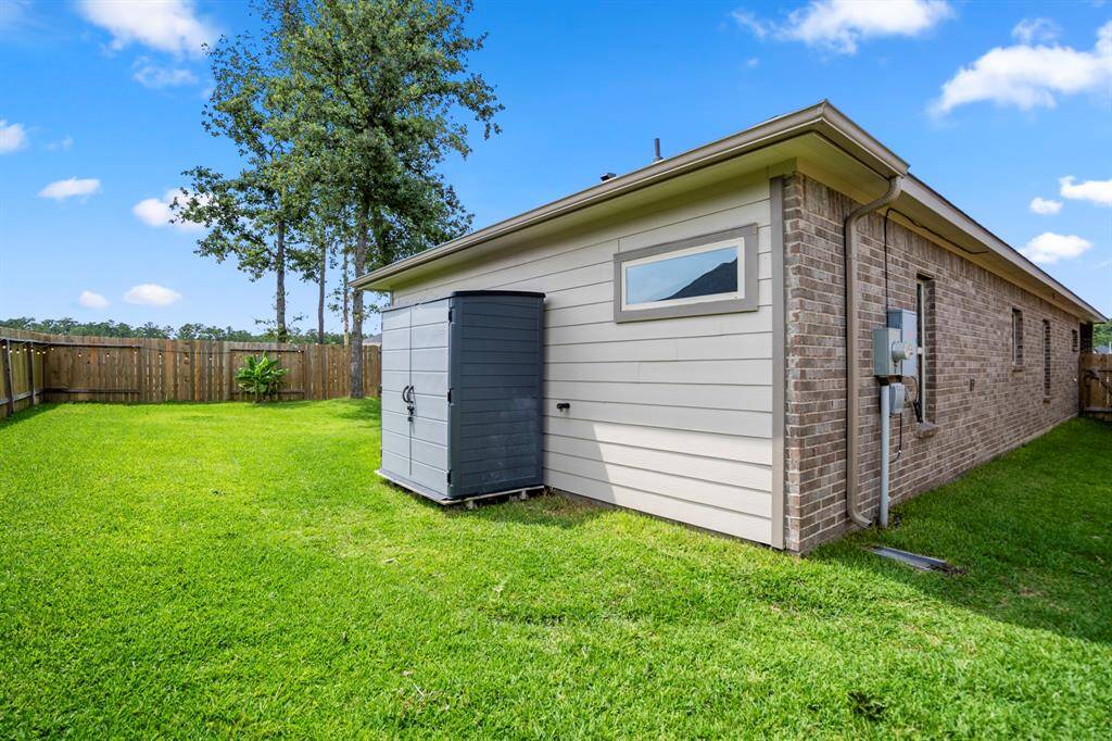 A peek at the side yard and a rare bonus for this price point: brick on three sides. Durable, low-maintenance, and a major step up from many new homes in this price point! Bonus: the extra shed and extended yard give you even more usable outdoor space.