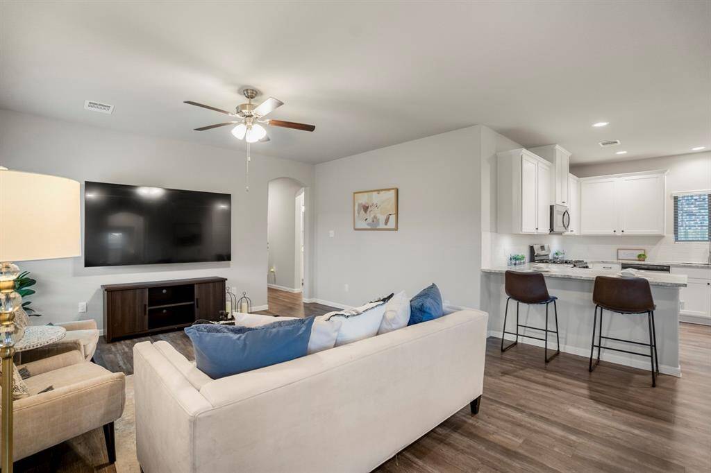 Whether you’re hosting game day or winding down with a movie, this living space was built to keep everyone connected. The bar seating opens directly into the kitchen, making it easy to chat with the cook or refill snacks mid-show. The arched opening leads back toward the front hallway, with the secondary bedrooms and guest bath tucked just out of view.