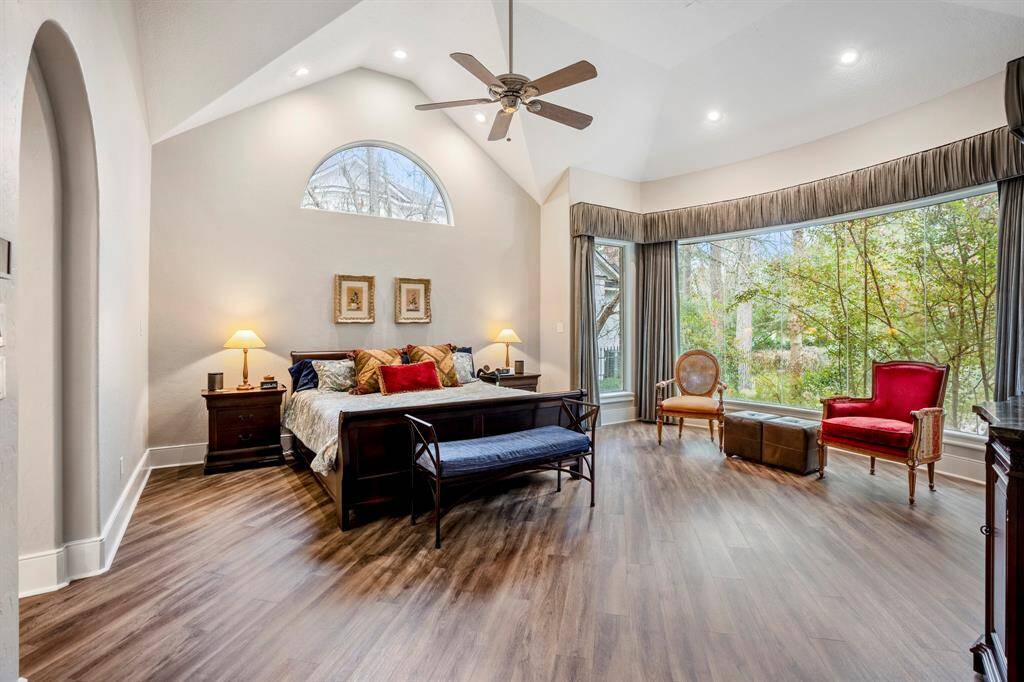 The primary suite is a sanctuary for the owners with vaulted ceilings and a sitting area with views overlooking the peaceful backyard.