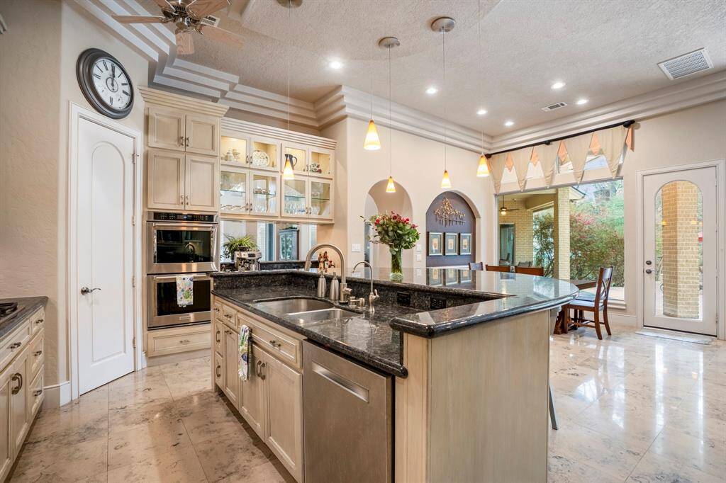 The kitchen features KitchenAid double convection ovens and a huge walk in pantry. The glass cabinets showcase your collections with the pass-through to the formal dining area providing convenient access.