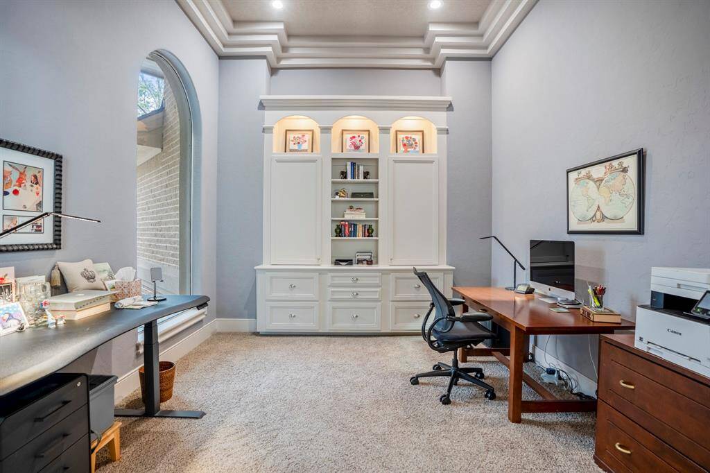The spacious study just off the living room, can be easily sharing by two, with views of the front yard and features a stylish lighted built-in with thoughtfully designed storage solutions.