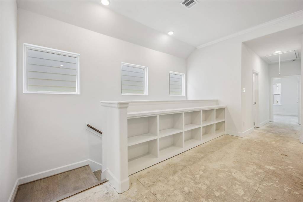 Versatile Game Room: A cozy, light-filled retreat with built-in shelving, perfect for relaxing, entertaining, or setting up an additional workspace.