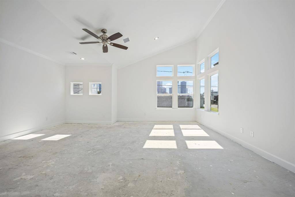 Primary Retreat: A spaciously lit sanctuary, complete with a ceiling fan for personalized comfort and views that take in Houston's scenic downtown facade. (Note: different elevation shown; schedule a viewing to see the the fabulous corner-window configuration in person).