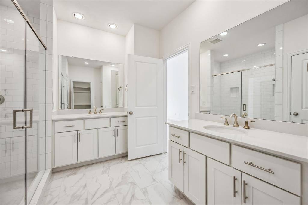 Spa-like Splendor: Dual vanities, a roomy linen closet, and a secluded water closet are set amid abundant space for an everyday spa experience right at home.
