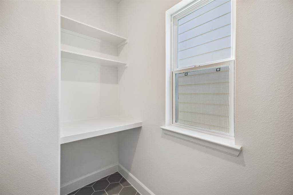Laundry Room Functionality: Thoughtfully designed with built-in shelving and a folding counter, this laundry room maximizes efficiency and natural light.