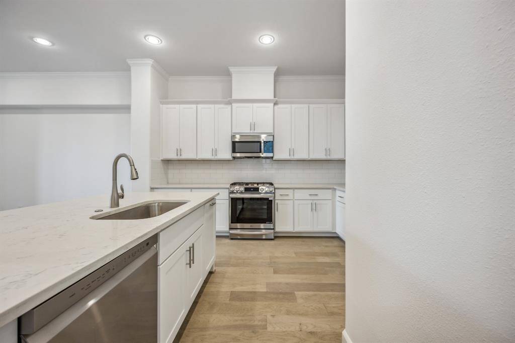 Culinary Excellence: Centered around a generous kitchen island, this modern chef's paradise boasts the latest in sleek stainless steel appliances from LG or Bosch, marrying function with sophistication.