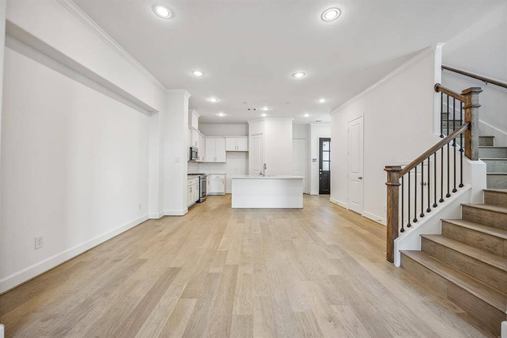 Elegant Ascension: The warm glow of wood floors not only grounds the dining room but also ascends, drawing the eye and spirit upward to the private sanctuaries above.