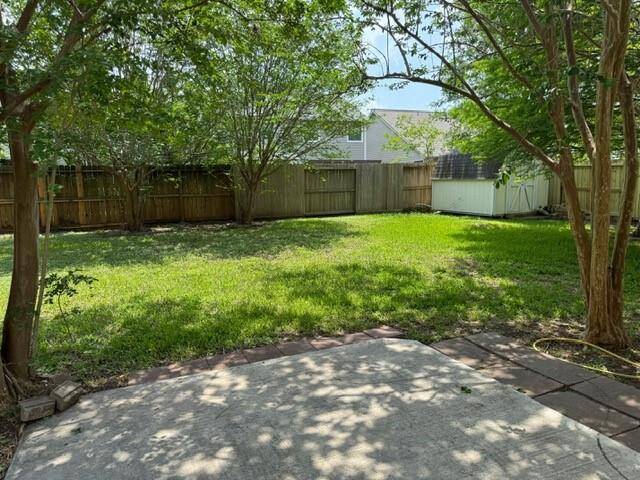 Back yard offers mature trees and a storage shed