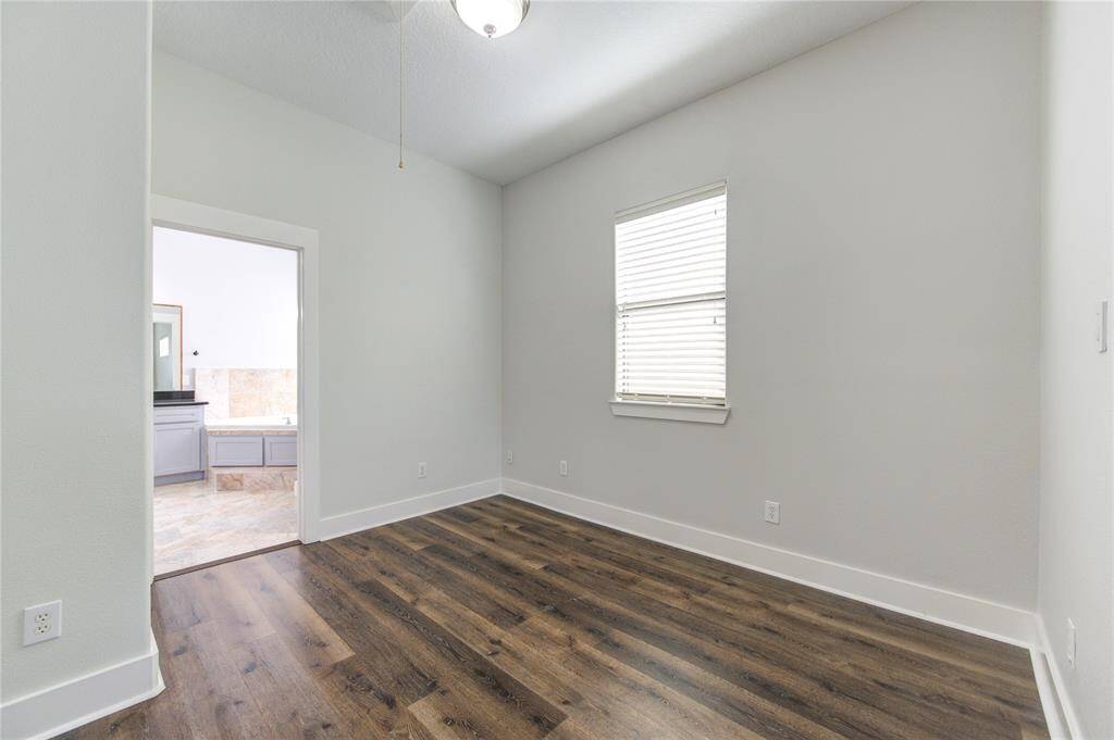 A separate sitting area provides a versatile space perfect for a home office, reading nook, or private lounge.