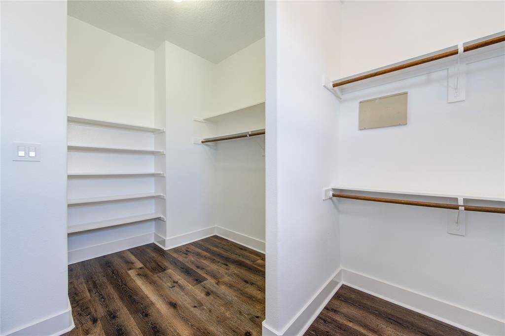 The spacious walk-in closet in the third-floor primary suite offers ample storage and organization, featuring custom shelving, built-in drawers, and hanging space to accommodate any wardrobe.