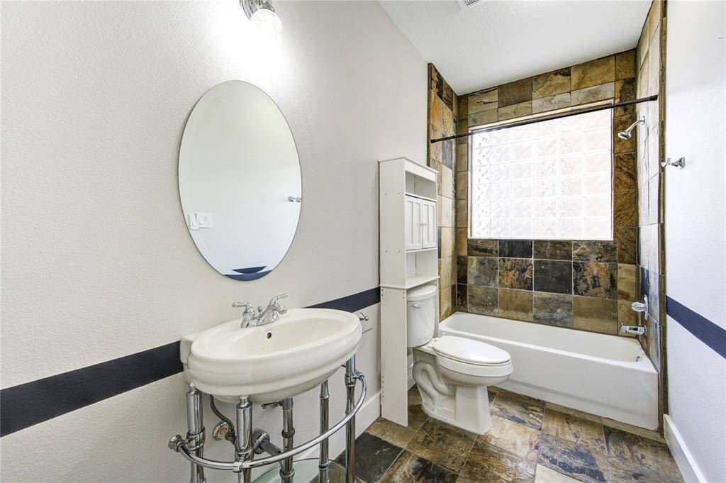 The en-suite bathroom for the third bedroom features a stylish pedestal sink that adds a touch of elegance and modern flair.