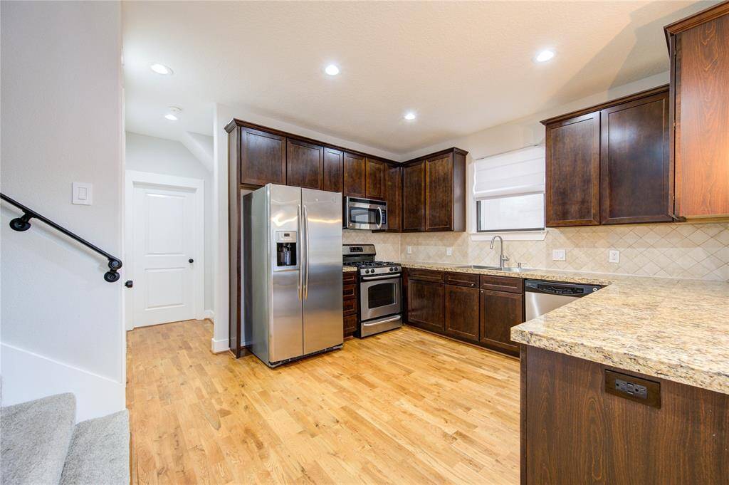 This beautifully designed gourmet kitchen showcases rich hardwood floors that seamlessly flow throughout, adding warmth and elegance to the space. Granite countertops provide ample prep and serving space, perfectly complementing the custom cabinetry that offers abundant storage.