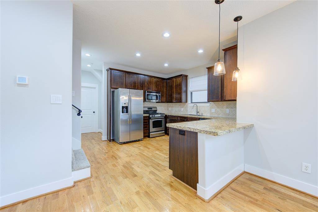 A chic tile backsplash enhances the modern aesthetic, while under-cabinet lighting creates a warm and inviting ambiance. The open-concept layout allows for easy entertaining, with a breakfast bar providing additional seating and workspace.